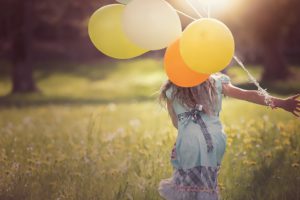 girl running with balloons