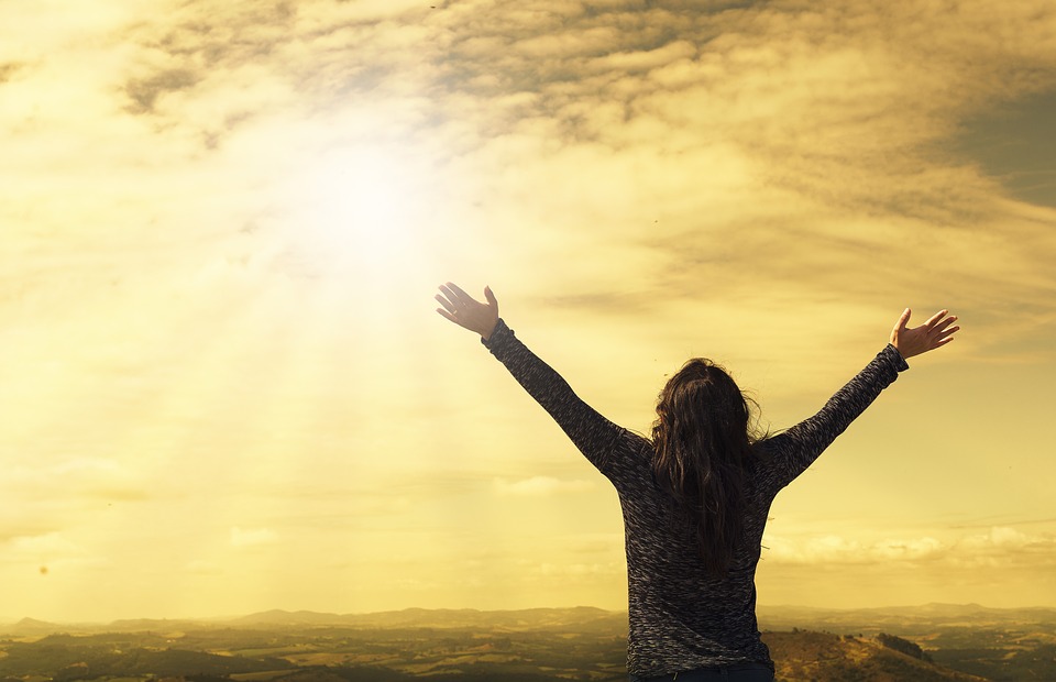 woman with hands lifted towards the sky